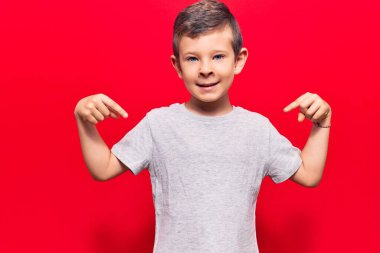 Hoş sarışın, günlük kıyafetler giyen, kendine güvenen, gülümseyen, kendini gururlu ve mutlu gösteren bir çocuk.. 