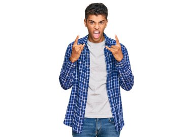 Genç, yakışıklı, Afro-Amerikalı, günlük kıyafetler giymiş, çılgın bir ifadeyle bağırıyor, elleri havada rock sembolü yapıyor. Müzik yıldızı. ağır kavram. 