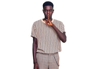 Gündelik giysiler giymiş genç Afro-Amerikan bir adam sessiz olmak istiyor. sessizlik ve gizli konsept. 