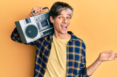 Kasetçalar tutan genç İspanyol adam, başarıyı mutlu bir gülümsemeyle kutlayan müzik dinliyor ve kazanan el kaldırarak ifade ediyor. 