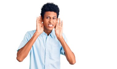 Gündelik giysiler giymiş genç Afro-Amerikan bir adam iki elini de kulak hareketlerini duymaya çalışıyor, dedikoduya meraklı. İşitme sorunu, sağır 