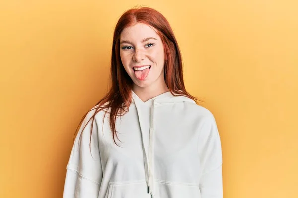 Young Red Head Girl Wearing Casual Sweatshirt Sticking Tongue Out — Stock Photo, Image