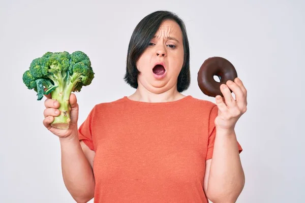 Donna Bruna Con Sindrome Con Broccoli Ciambella Cioccolato Faccia Shock — Foto Stock