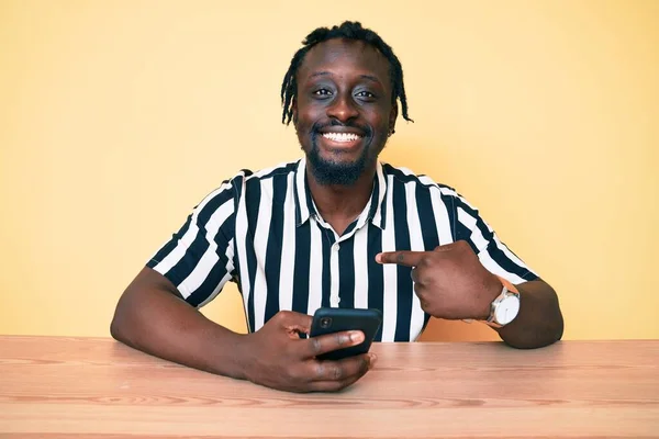 Giovane Uomo Afroamericano Con Trecce Utilizzando Smartphone Seduto Sul Tavolo — Foto Stock