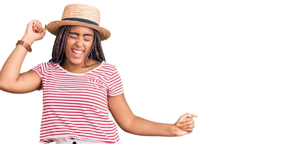 年轻的非洲裔美国女人 头戴辫子 头戴夏帽 欢快欢快地跳舞 微笑着 随意而自信地听着音乐 — 图库照片