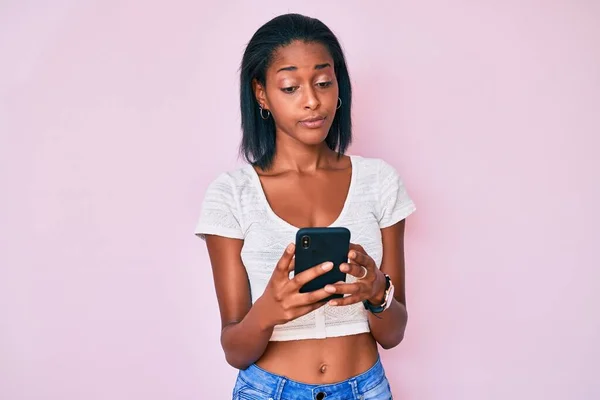 Mujer Afroamericana Joven Usando Teléfono Inteligente Relajado Con Expresión Seria —  Fotos de Stock