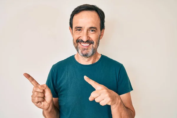 Homem Hispânico Meia Idade Apontando Com Dedos Para Lado Sorrindo — Fotografia de Stock
