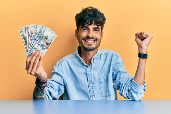 Νεαρός Ισπανός Που Κρατάει Δολάρια Στο Τραπέζι Ουρλιάζοντας Περήφανος Γιορτάζοντας — Φωτογραφία Αρχείου