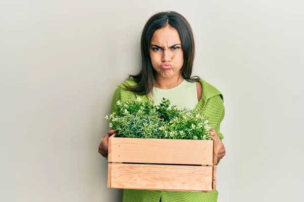 Young Brunette Woman Holding Wooden Plant Pot Puffing Cheeks Funny — Stock Photo, Image