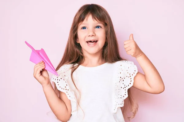 Kleine Kaukasische Mädchen Mit Langen Haaren Halten Papierflugzeug Lächelt Glücklich — Stockfoto