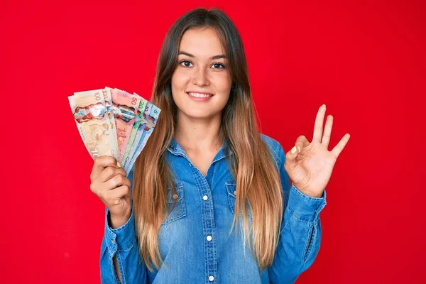 Mulher Caucasiana Bonita Segurando Dólares Canadenses Fazendo Sinal Com Dedos — Fotografia de Stock