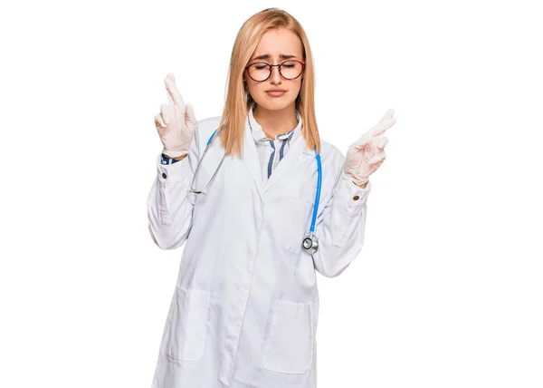 Mulher Branca Bonita Vestindo Uniforme Médico Estetoscópio Gesto Dedo Cruzado — Fotografia de Stock