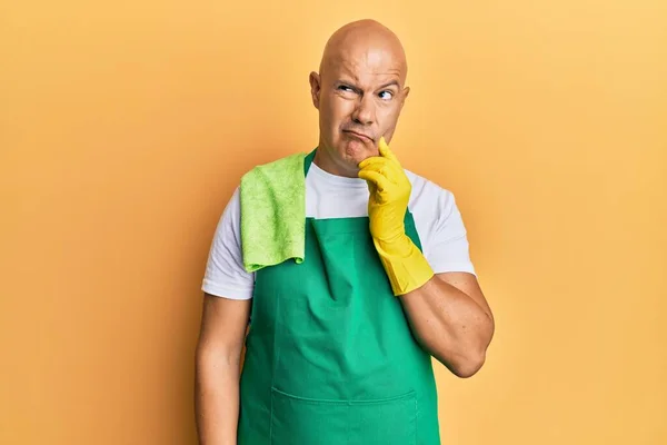 Medelålders Skallig Man Förkläde Med Rengöringshandskar Allvarligt Ansikte Tänker Fråga — Stockfoto