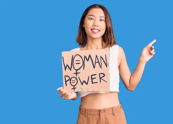 Młoda Piękna Chińska Dziewczyna Trzyma Kobieta Power Banner Zaskoczony Pomysłem — Zdjęcie stockowe