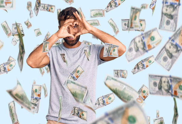 Молодой латиноамериканец в повседневной одежде делает форму сердца с рукой и пальцами, улыбаясь, глядя сквозь знак