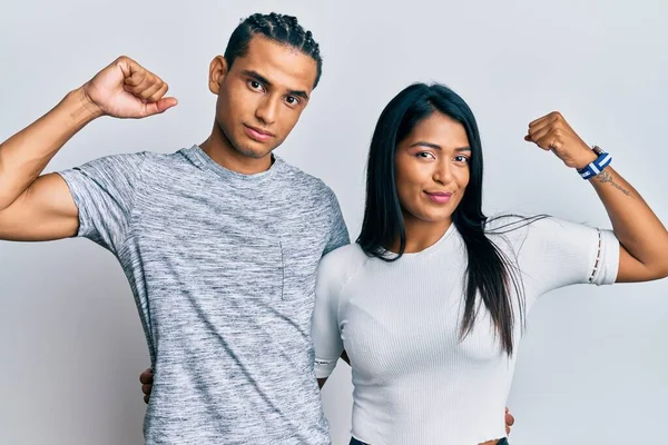年轻的拉丁夫妇穿着休闲装 强壮的人展示臂膀肌肉 自信而自豪 — 图库照片