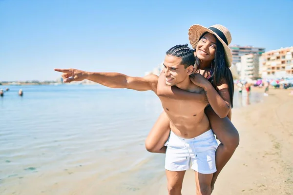 Jovem Casal Latino Abraçando Apontando Para Horizonte Com Dedo Praia — Fotografia de Stock