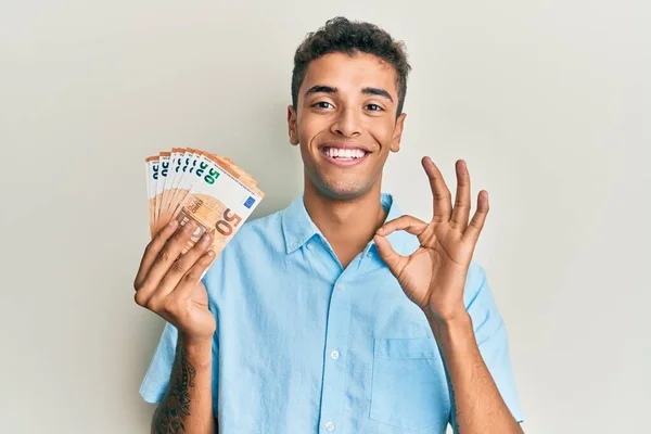Joven Hombre Afroamericano Guapo Sosteniendo Racimo Billetes Euros Haciendo Señal — Foto de Stock
