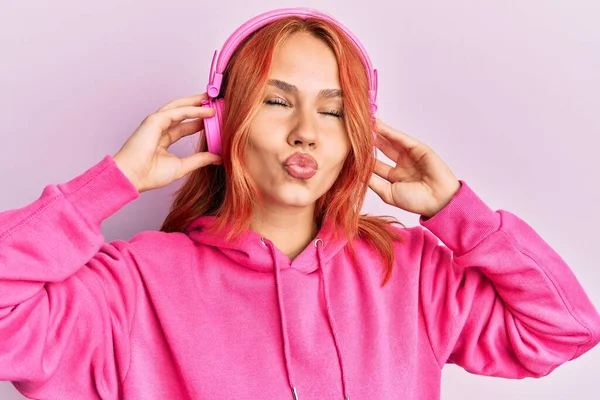 Joven Pelirroja Escuchando Música Usando Auriculares Mirando Cámara Soplando Beso — Foto de Stock