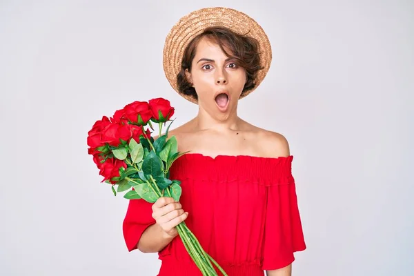 Jovem Hispânica Usando Chapéu Segurando Flores Assustadas Espantadas Com Boca — Fotografia de Stock