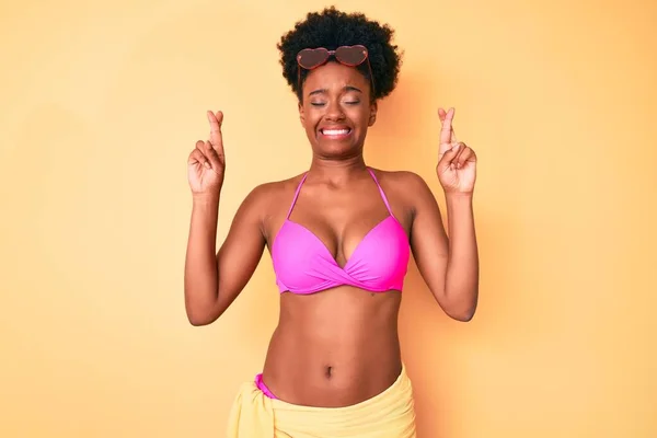 Młoda Afroamerykanka Bikini Gestykulująca Palcami Uśmiechnięta Nadzieją Zamkniętymi Oczami Szczęście — Zdjęcie stockowe