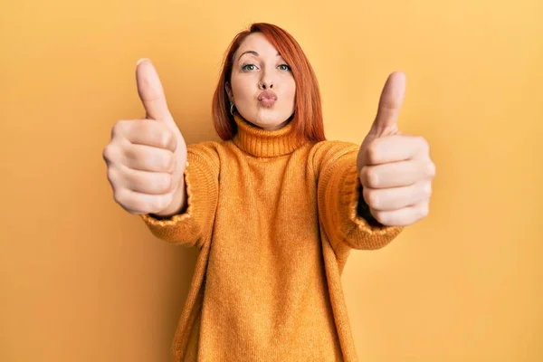 Beautiful Redhead Woman Doing Thumbs Positive Gesture Looking Camera Blowing — Stock Photo, Image