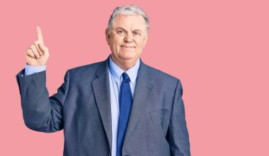 İş ceketi giyen yaşlı gri saçlı adam başarılı bir fikirle işaret ediyor. Heyecanlı ve mutlu. Bir numara.. 