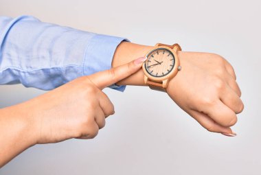 Kol saati takan beyaz iş kadınının eli. İzole edilmiş beyaz arkaplanı izlemek için parmakla gösteriliyor