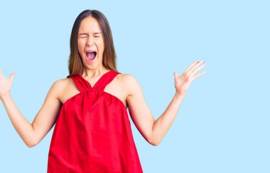 Güzel, esmer, gündelik kıyafetler giymiş genç bir kadın başarı için deli ve çılgınlığı kutluyor kollarını kaldırmış, gözlerini kapatmış heyecanlı çığlıklar atıyor. Kazanan konsept 