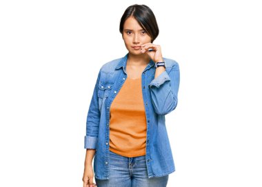 Kısa saçlı, sıradan kot ceket giyen, ağzı ve dudakları parmakları fermuarlı, güzel İspanyol bir kadın. gizli ve sessiz, tabu konuşması 