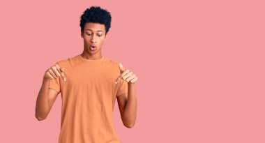 Gündelik giysiler giymiş genç Afro-Amerikan bir adam parmaklarını göstererek reklamını yapıyor, şaşırmış yüzünü ve ağzını açıyor. 