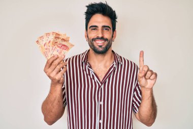 Meksika pezosu sakallı yakışıklı adam bir fikir veya soru işareti ile gülümsüyor. 