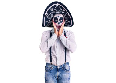 Arka planda ölü kostümü giymiş bir adam korkmuş ve şok olmuş, şaşırmış ve şaşırmış bir yüz ifadesi takınıyor. 