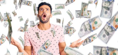 Genç, yakışıklı, sıradan kıyafetler giyen çılgın ve deli gibi bağıran saldırgan bir ifade ve kollarla bağıran bir İspanyol. hüsran kavramı.