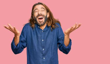 Uzun saçlı ve sakallı çekici bir adam çılgın ve çılgın başarısını kutluyor kollarını kaldırmış ve gözlerini kapamış heyecanlı çığlıklar atıyor. Kazanan konsept 