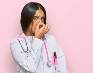 Güzel İspanyol kadın doktor üniforması giyiyor ve steteskop kokulu ve iğrenç bir koku alıyor. Dayanılmaz bir koku. Parmakları burnunda nefesini tutuyor. Kötü kokuyor. 