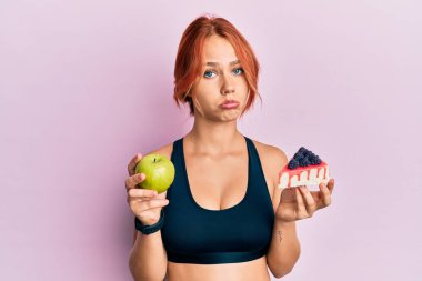 Genç, güzel, kızıl saçlı, elinde yeşil elma ve pasta dilimi tutan bir kadın. Depresyonda ve üzüntüden ağlıyor. Kızgın ve korkmuş. hüzünlü ifade. 