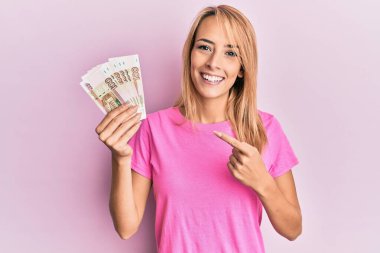 Güzel sarışın kadın elinde 100 rusya rublesi ile gülümsüyor. 