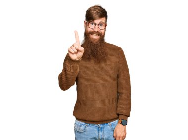 Sıradan kıyafetler giyen ve gözlüklü genç İrlandalı kızıl adam başarılı bir fikir olduğunu işaret ediyor. Heyecanlı ve mutlu. Bir numara.. 