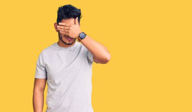 Yakışıklı Latin Amerikalı, sıradan tişörtler giyen, gülümseyen ve gülen, gözlerini kapatan genç bir adam. kör kavram. 