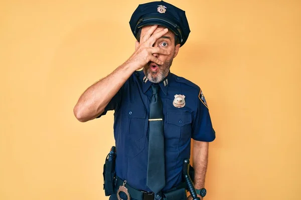 Hispánec Středního Věku Policejní Uniformě Vykukuje Šoku Zakrývá Obličej Oči — Stock fotografie