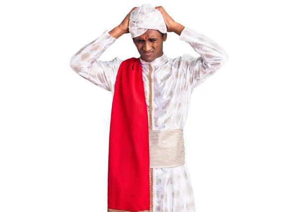 伝統的なシャーワニを身に着けているアフリカのハンサムな男は痛みや片頭痛のために絶望的でストレスを受けた服を見た 手を頭に — ストック写真