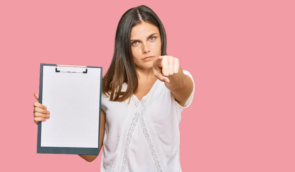 Young Caucasian Woman Holding Clipboard Blank Space Pointing Finger Camera — Stock Photo, Image