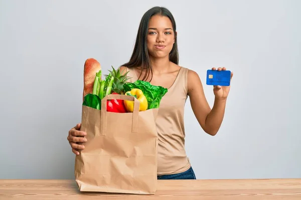 Hermosa Mujer Hispana Sosteniendo Comestibles Tarjetas Crédito Inflando Mejillas Con —  Fotos de Stock