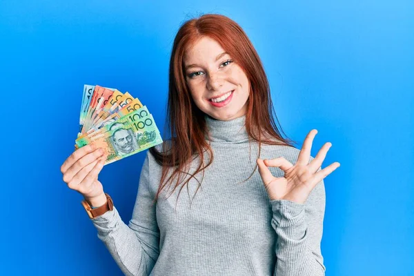 Young Red Head Girl Holding Australian Dollars Doing Sign Fingers — Foto de Stock