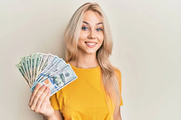 Krásná Kavkazská Blondýnka Drží Dolary Vypadá Pozitivně Šťastně Stojící Usmívá — Stock fotografie