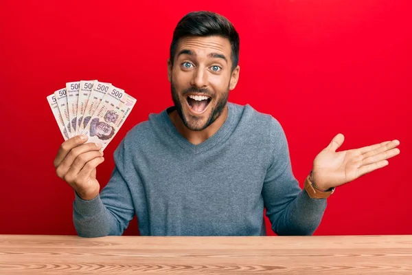 Hombre Hispano Guapo Sosteniendo Pesos Mexicanos Celebrando Logro Con Sonrisa — Foto de Stock