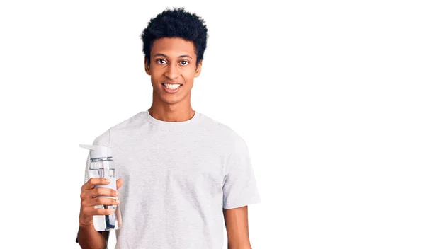 身穿运动服的年轻的非洲裔美国人拿着水瓶 面带微笑 面带微笑 面带微笑 看上去很积极 很快乐 — 图库照片