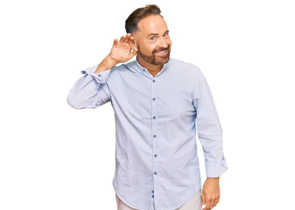 噂やゴシップに耳を傾ける耳の上に手で笑みを浮かべてビジネスシャツを着てハンサムな中年の男性 聴覚障害の概念 — ストック写真