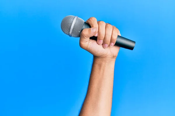 Dłoń Latynoskiego Człowieka Trzymającego Mikrofon Odizolowanym Niebieskim Tle — Zdjęcie stockowe